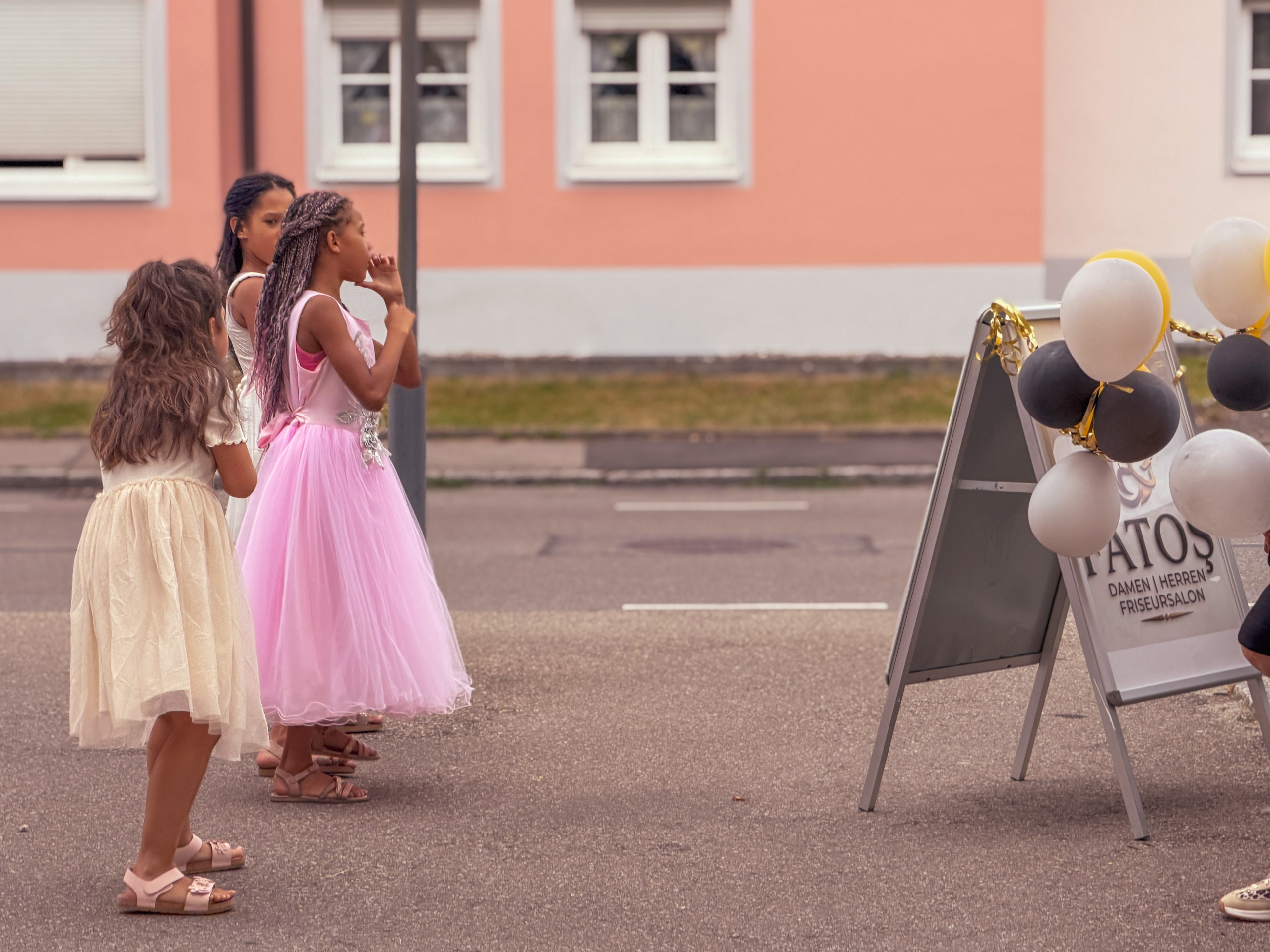 Festlich gekleidete Kinder am Aufsteller des Salons