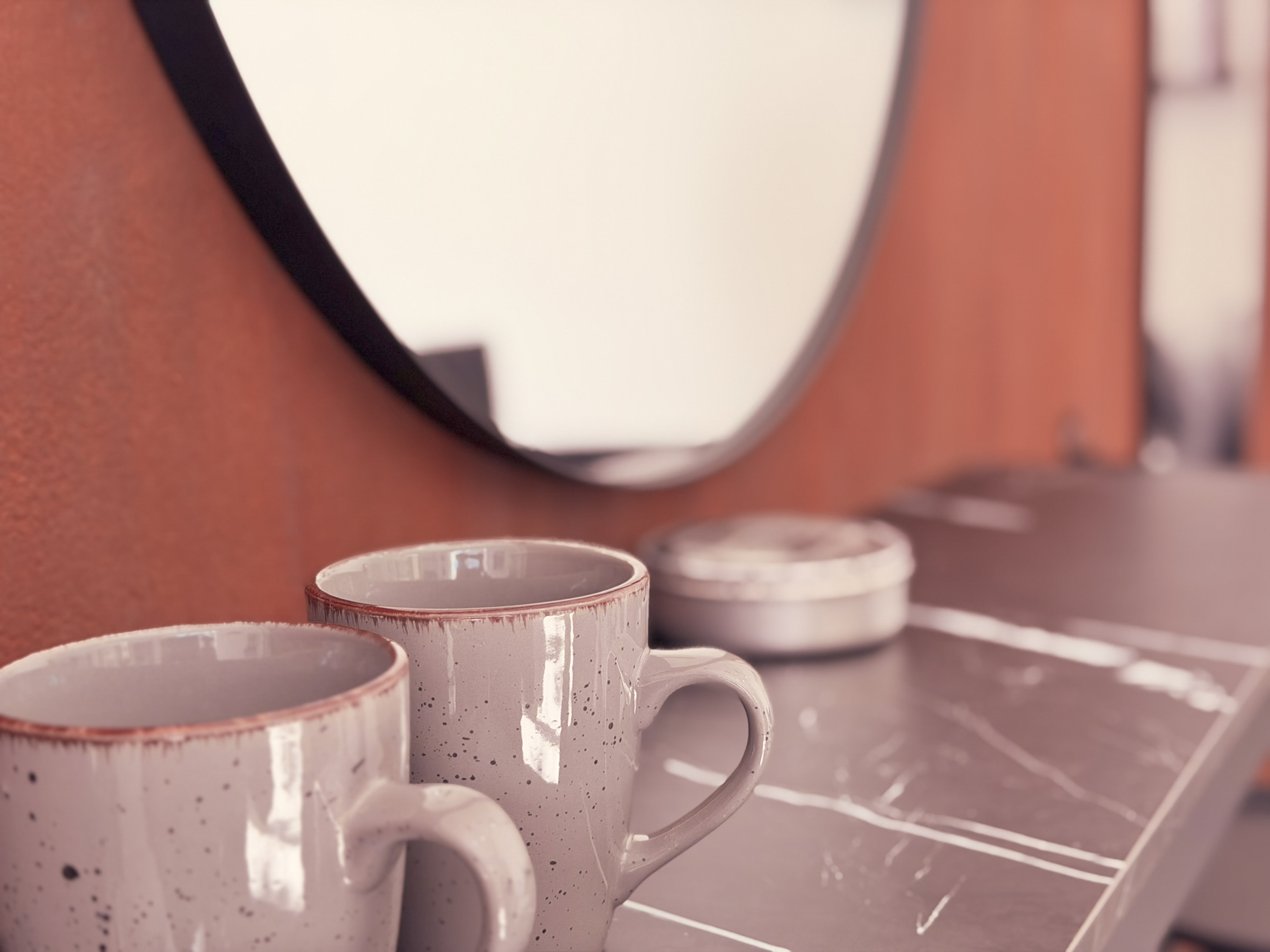 Kaffeetassen am runden Spiegel